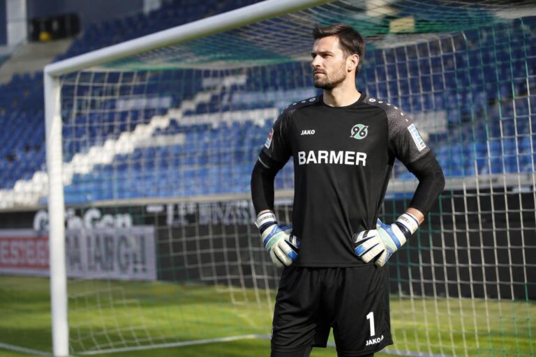 Goalkeeper standing calmly in front of an empty net after the final whistle, illustrating a clean sheet with no goals conceded