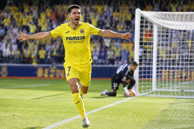 Villarreal forward celebrating a goal past a beaten goalkeeper, illustrating a BTTS (both teams to score) match outcome